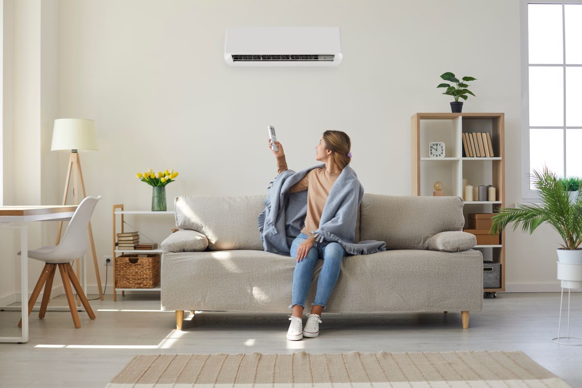 lady on couch turning on ac
